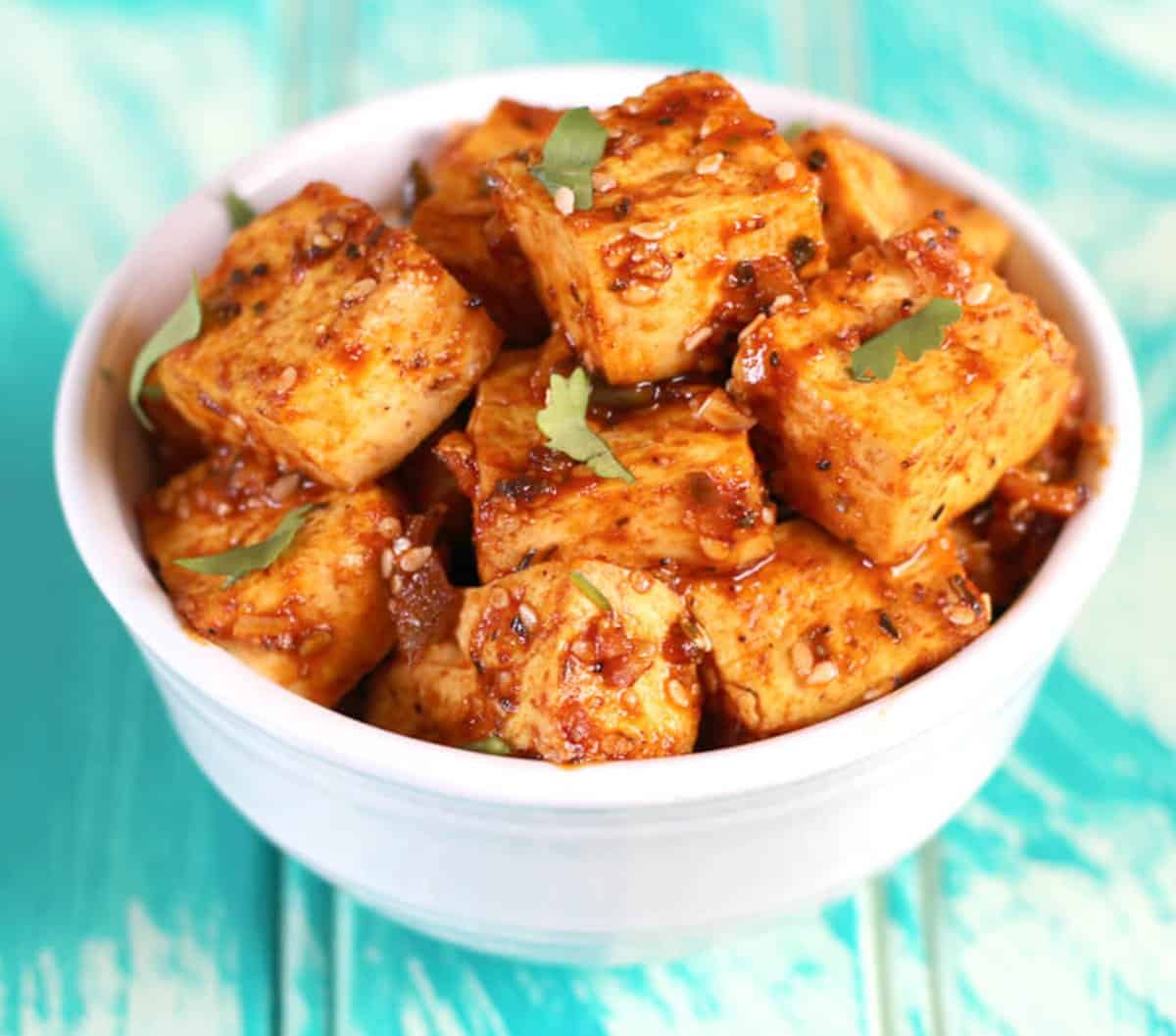 Simple and delicious Tofu dish tossed in honey and Sriracha sauce in a bowl.