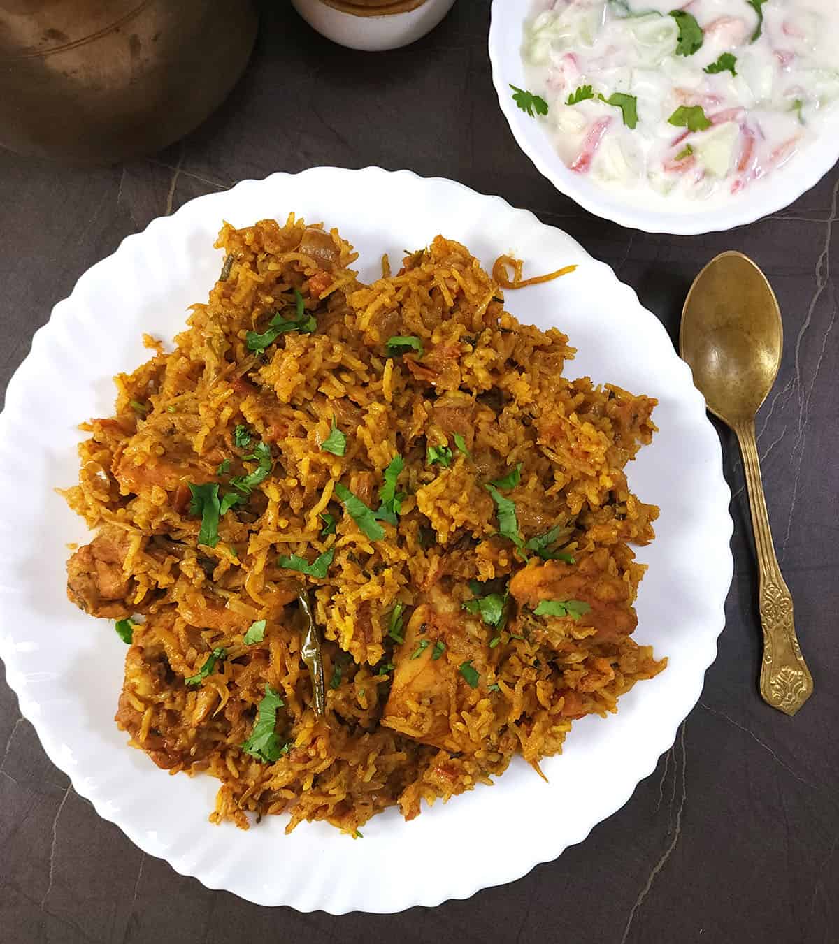 Spicy Chettinad style chicken biryani recipe served with onion raita. A perfect Indian meal. 