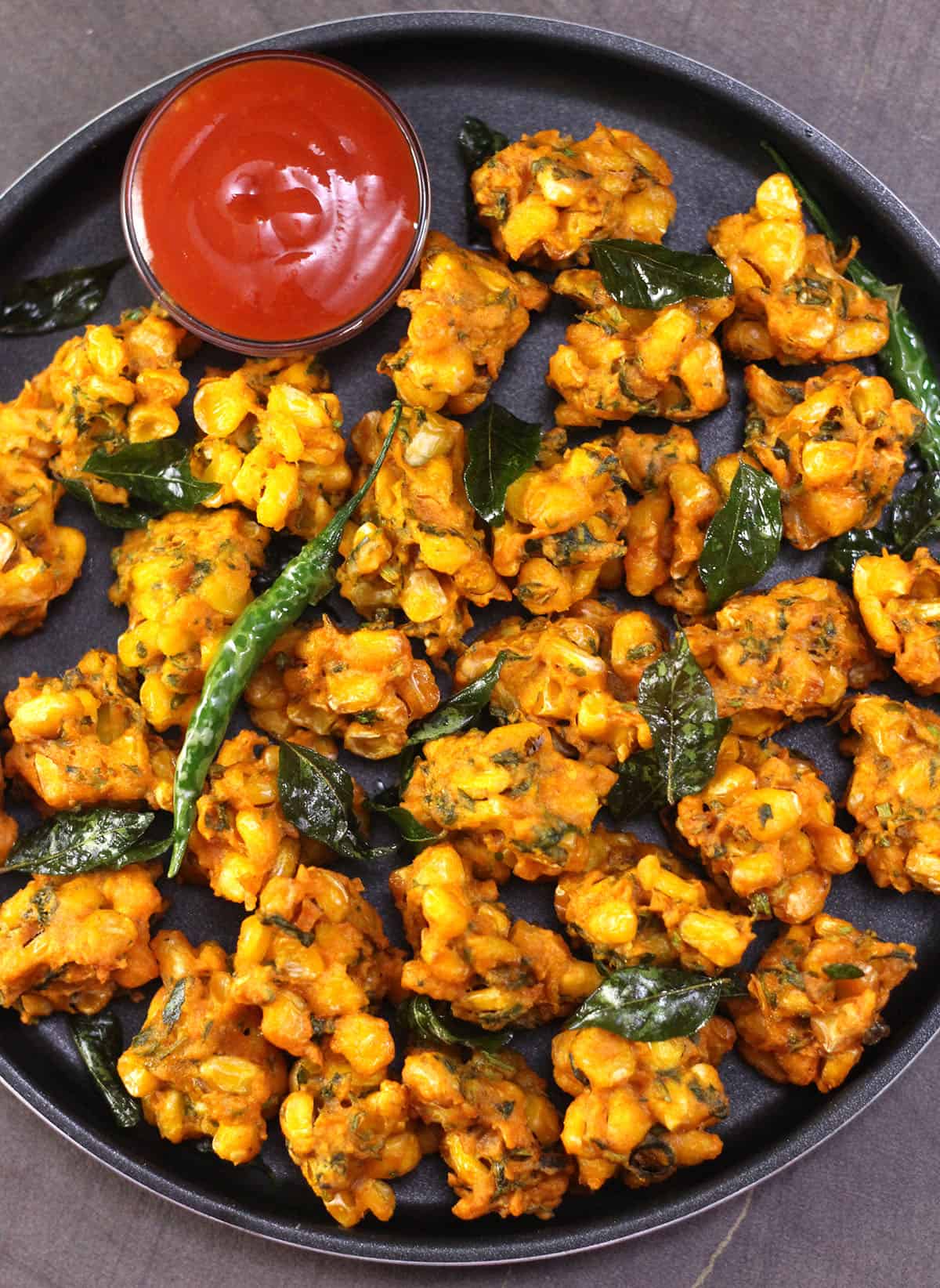 crispy corn pakoda (fritters) - with tomato ketchup or chutney and a cup of hot tea or coffee. 