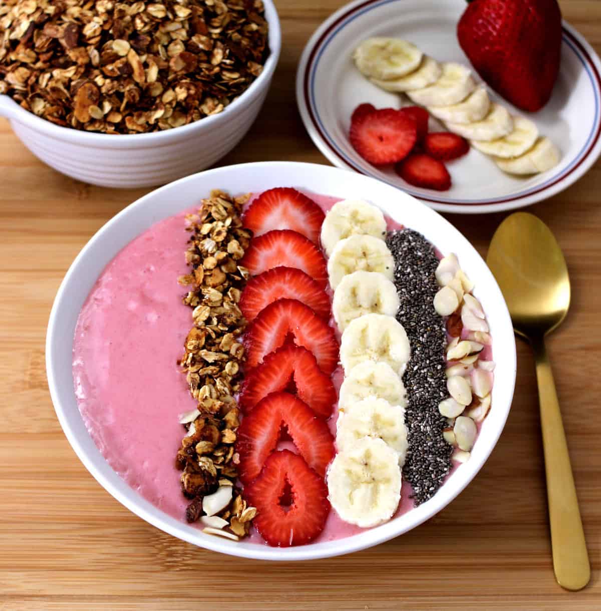 Breakfast and post-workout meal idea - strawberry banana smoothie bowl with toppings.
