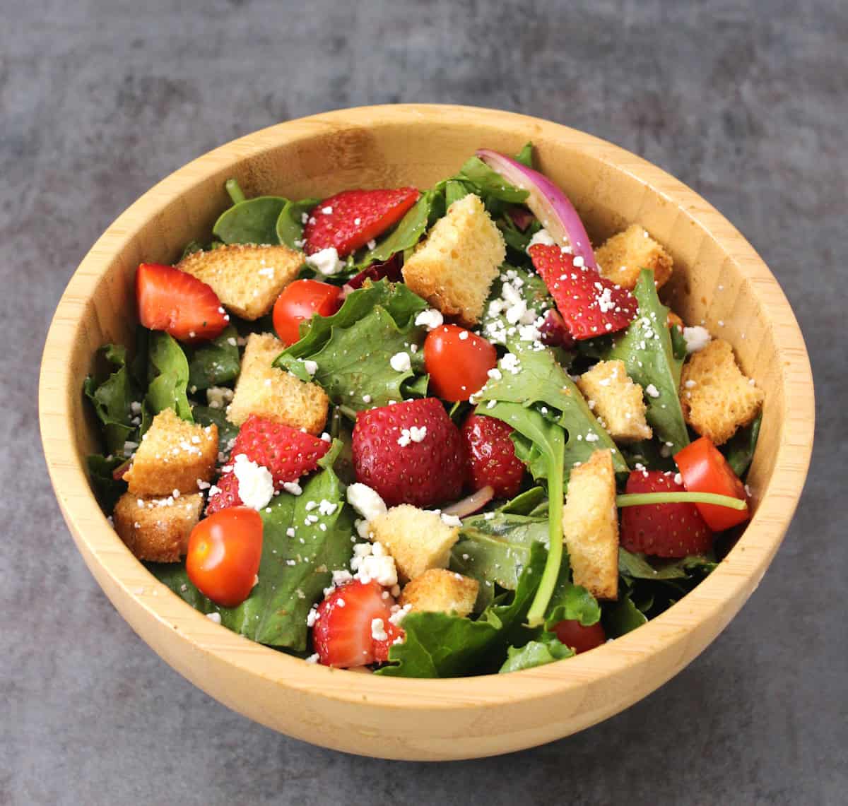 Fresh summer strawberry salad with mixed greens (spinach, arugula), feta, balsamic dressing.