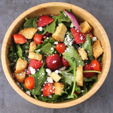 Strawberry Salad with mixed greens, feta cheese, onions, tomatoes, and balsamic vinaigrette dressing.