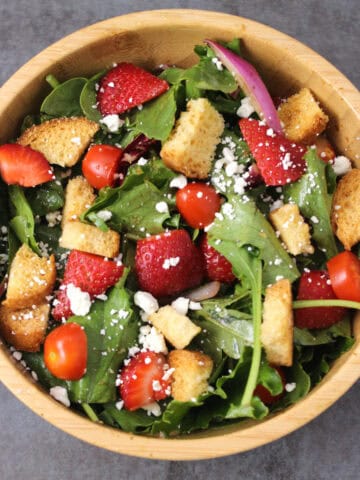 Strawberry Salad with mixed greens, feta cheese, onions, tomatoes, and balsamic vinaigrette dressing.